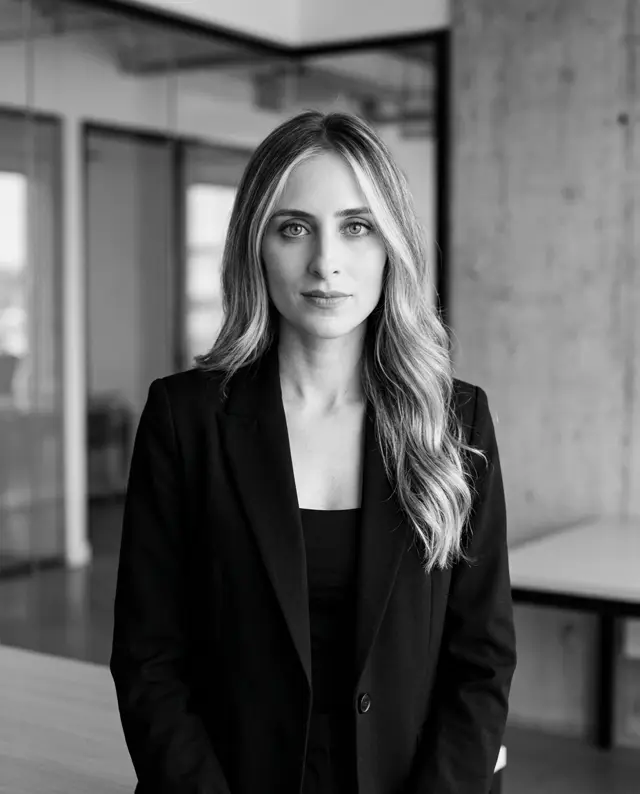 Nadine Imad, chief legal officer of Daut Labz, in a black blazer in a modern glass-walled office.